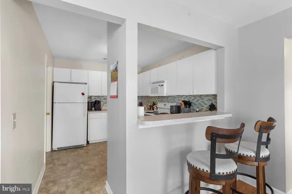 a kitchen with stainless steel appliances granite countertop a table and chairs in it