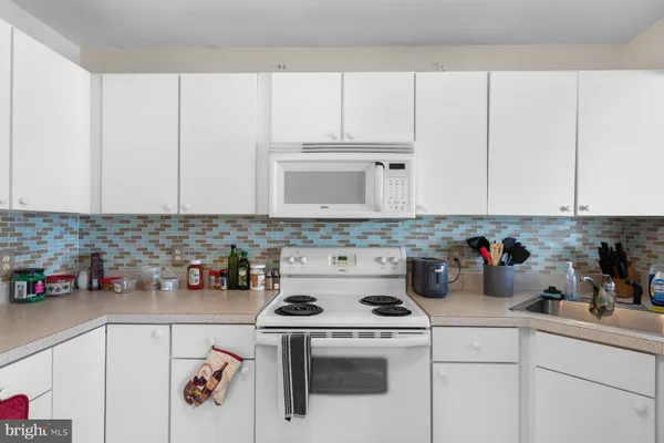 a white kitchen with a stove and cabinets