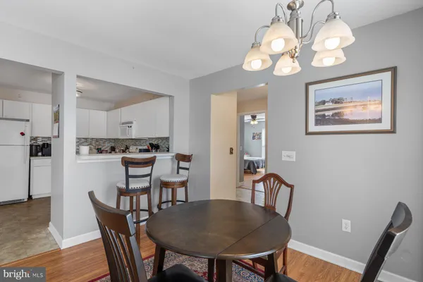 a view of a dining room with furniture a chandelier and wooden floor