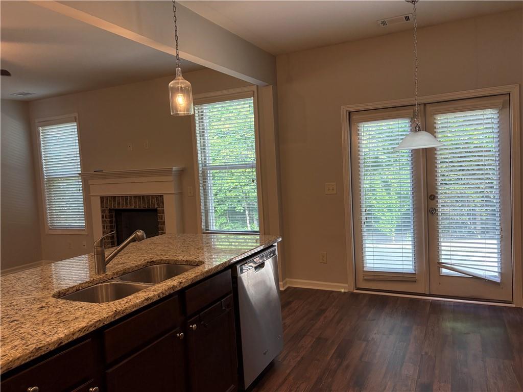 5934 Watersdown Way Flowery Branch, GA 30542 - Photo 10 of 28 a kitchen with granite countertop a sink a window and wooden floor