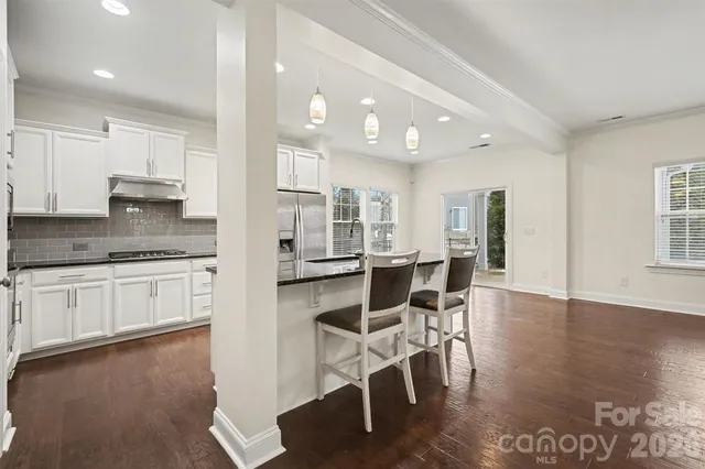 a kitchen with stainless steel appliances a stove top oven and a refrigerator