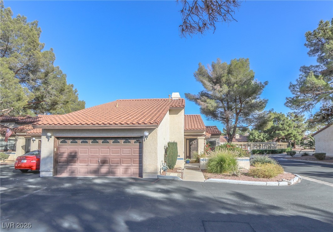 Mediterranean / spanish house featuring a tile roof, stucco siding, a chimney, and a​​‌​​​​‌​​‌‌​‌‌​​‌​​​​‌​​​‌‌​‌‌‌ garage