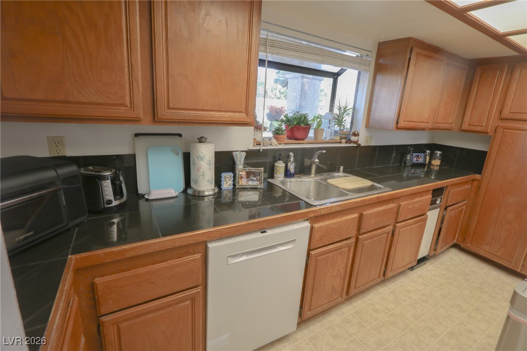 3201 La Mancha Way Henderson, NV 89014 - Photo 11 of 43 Kitchen with dishwasher, brown cabinetry, and light floors