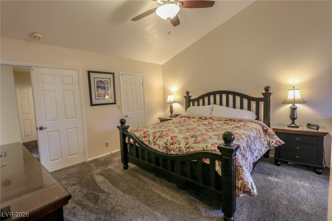 3201 La Mancha Way Henderson, NV 89014 - Photo 21 of 43 Bedroom with vaulted ceiling, dark colored carpet, and a ceiling fan