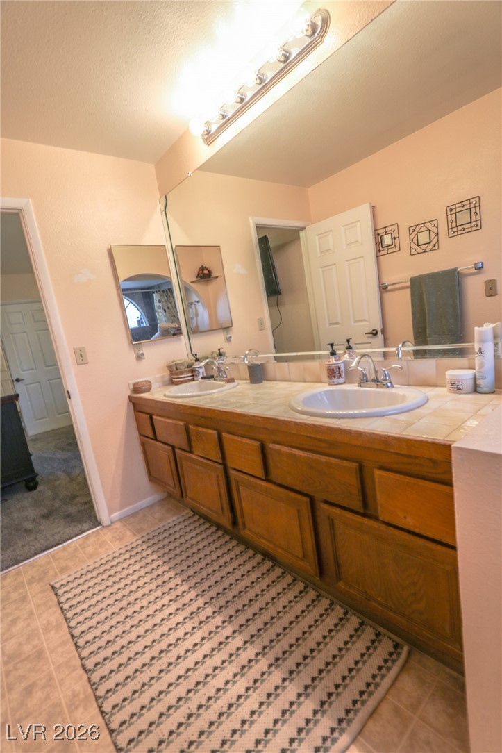 3201 La Mancha Way Henderson, NV 89014 - Photo 22 of 43 Full bathroom with double vanity and light tile patterned floors