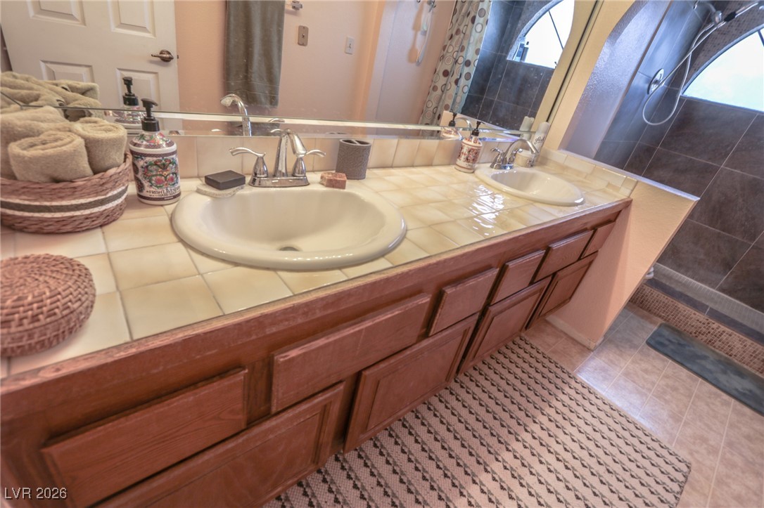 3201 La Mancha Way Henderson, NV 89014 - Photo 24 of 43 Full bathroom with tiled shower, double vanity, and light tile patterned flooring