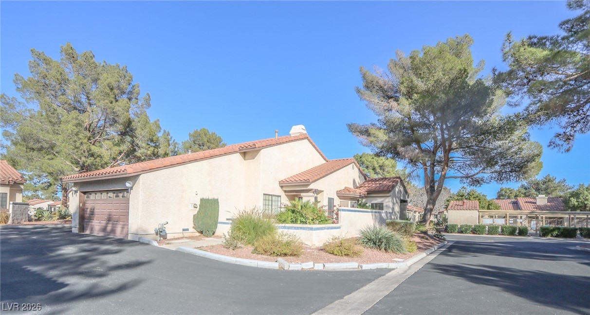 3201 La Mancha Way Henderson, NV 89014 - Photo 32 of 43 View of side of property featuring stucco siding, a tiled roof, and an attached garage