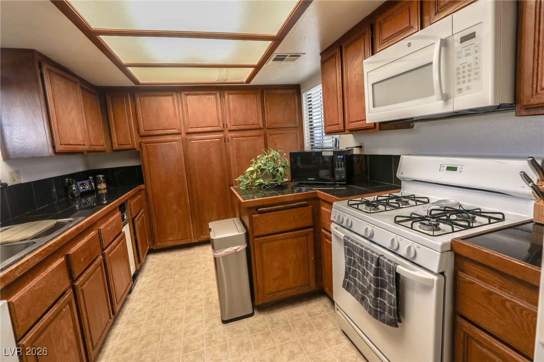 3201 La Mancha Way Henderson, NV 89014 - Photo 8 of 43 Kitchen featuring white appliances and brown cabinets