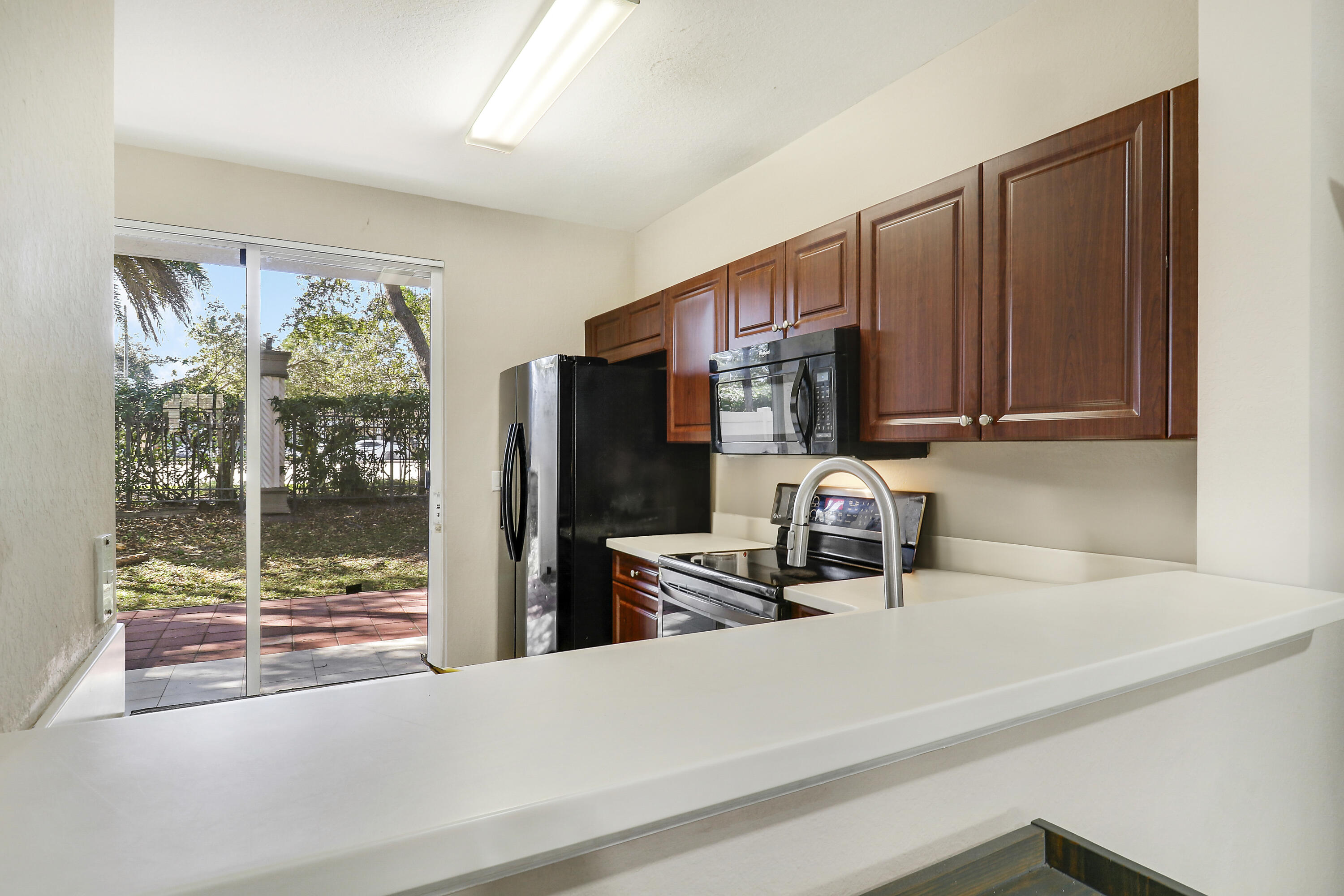 4170 Napoli Lake Drive Riviera Beach, FL 33410 - Photo 12 of 36 a kitchen with a sink a refrigerator and a window