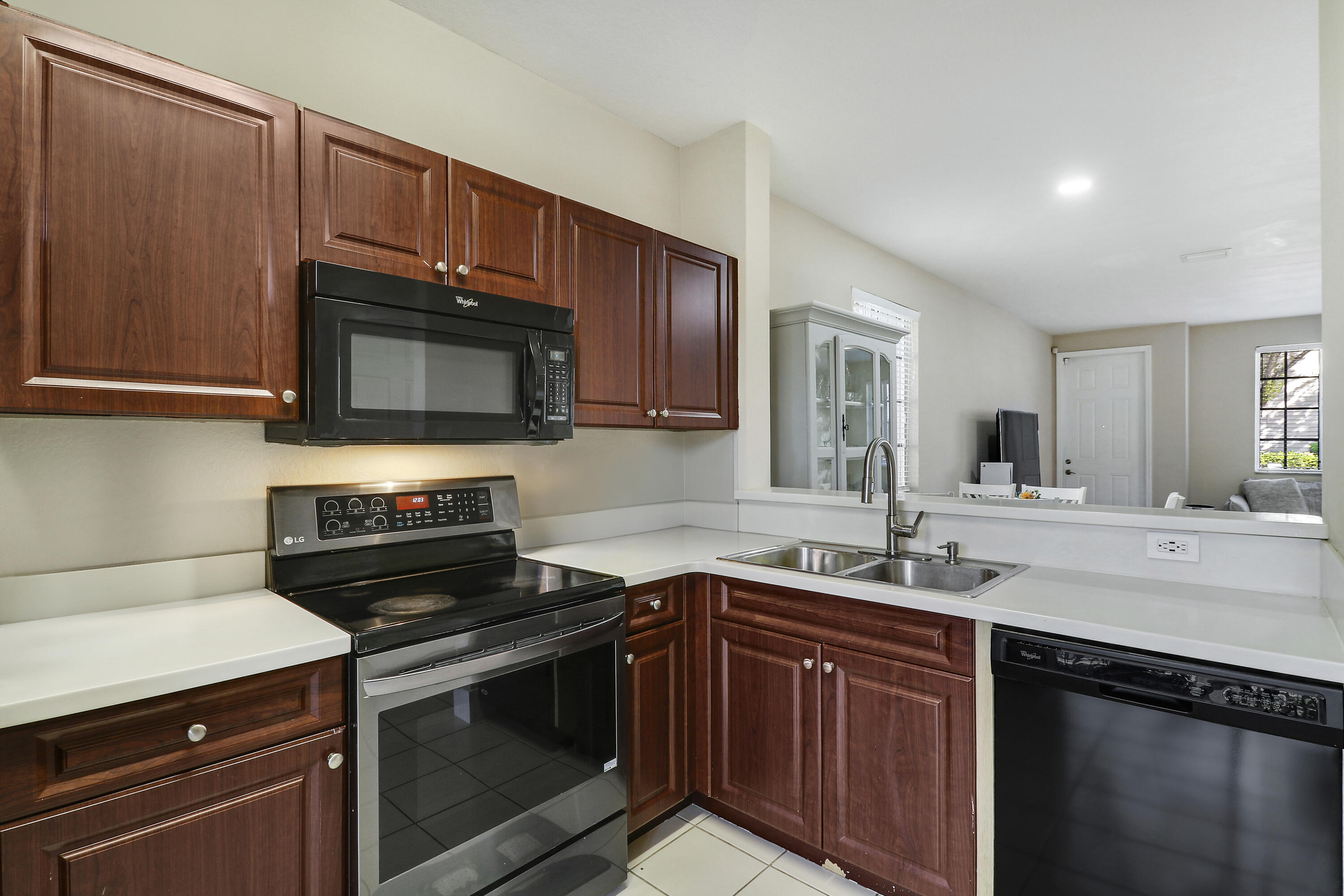 4170 Napoli Lake Drive Riviera Beach, FL 33410 - Photo 16 of 36 a kitchen with sink a microwave a stove and cabinets