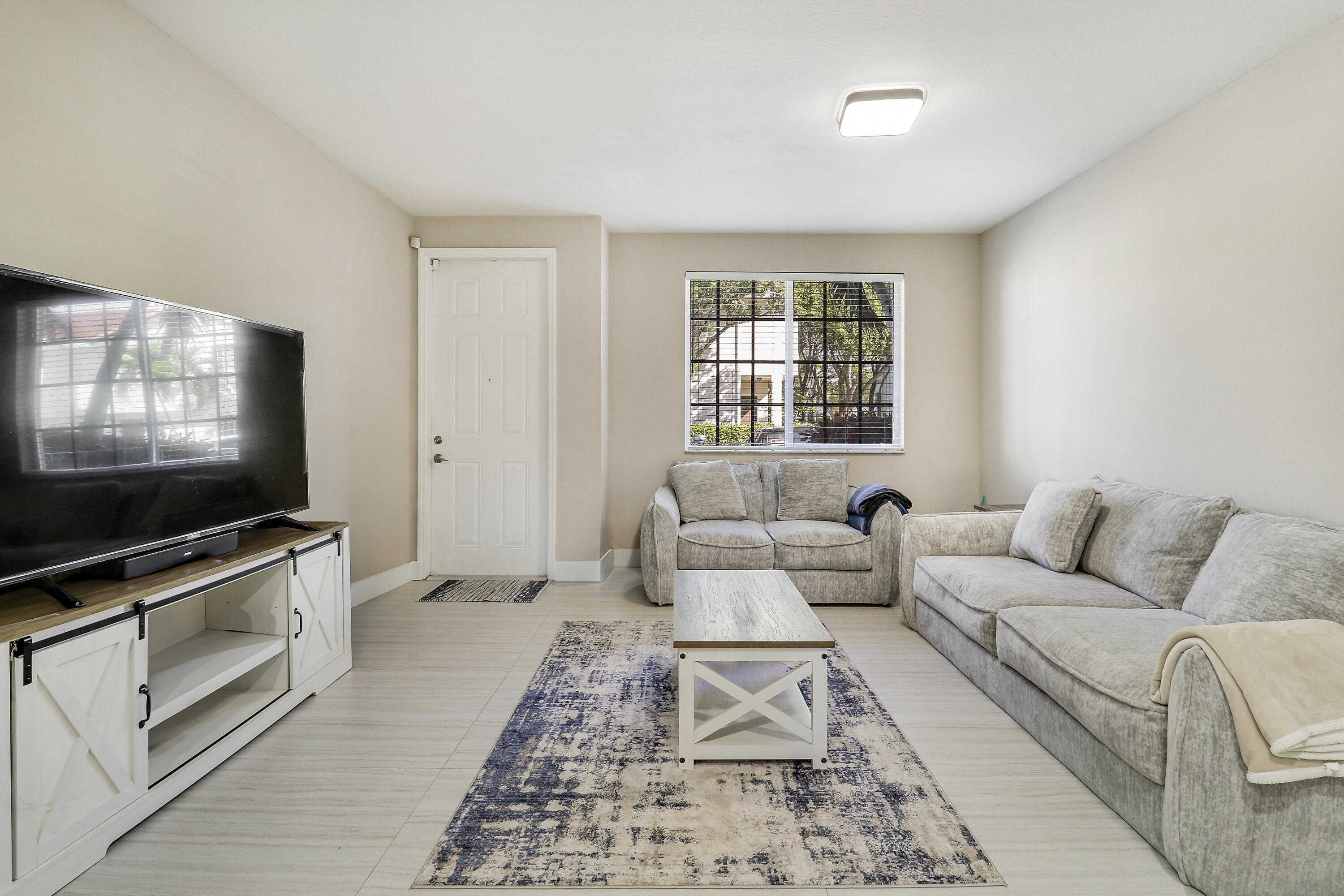 4170 Napoli Lake Drive Riviera Beach, FL 33410 - Photo 3 of 36 a living room with furniture and a flat screen tv