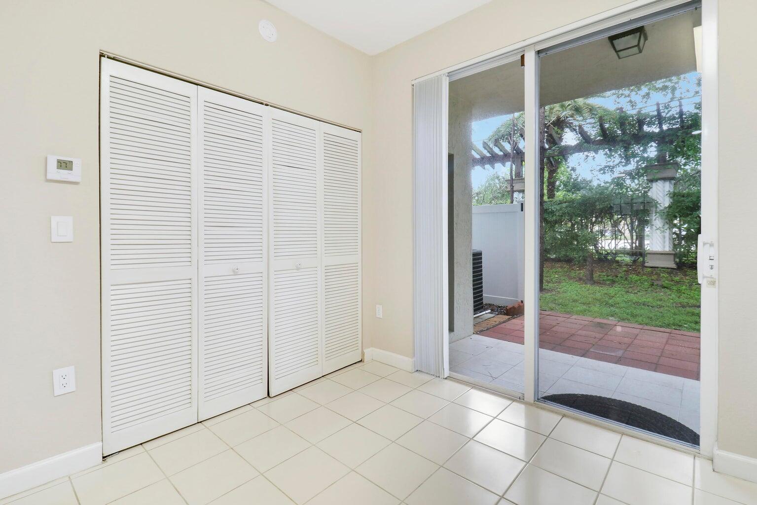 4170 Napoli Lake Drive Riviera Beach, FL 33410 - Photo 8 of 36 an empty room with sliding glass door and garden view