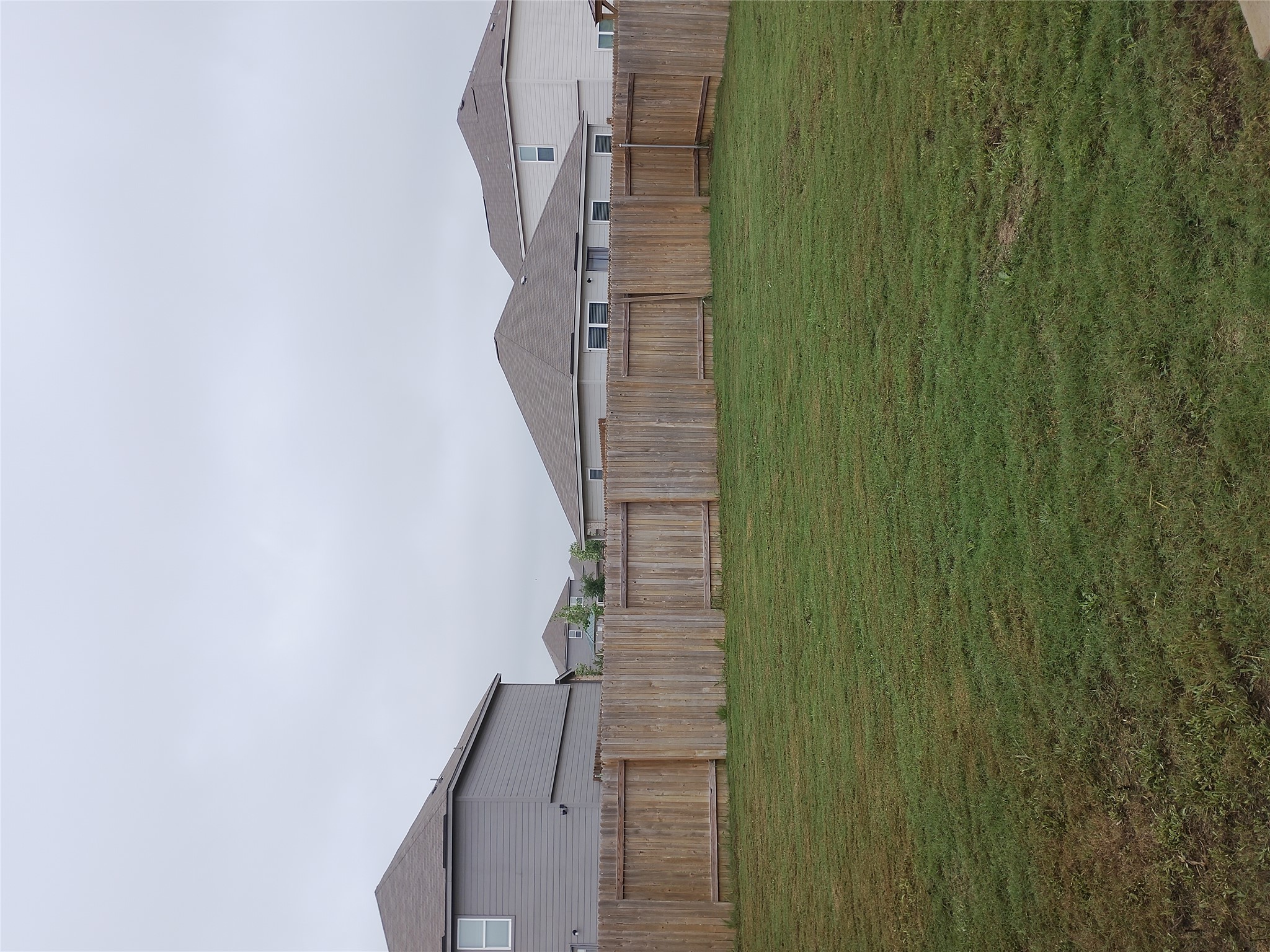 14024 Prairie Schooner Pass Elgin, TX 78621 - Photo 5 of 20 Expansive backyard featuring a natural wood privacy fence surrounding a large grassy area