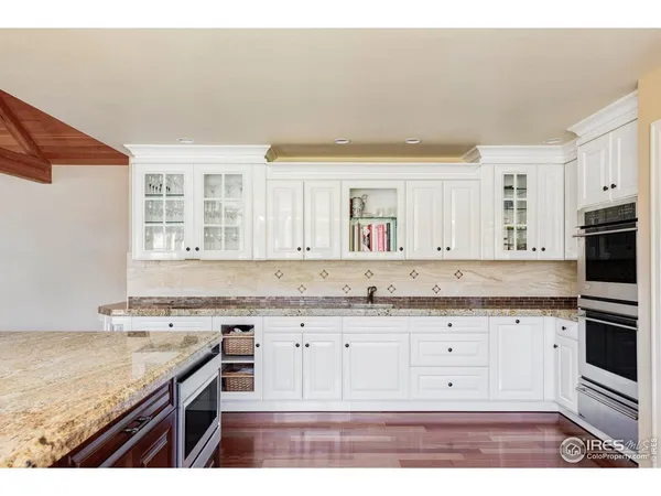 a kitchen with granite countertop a sink a stove and cabinets