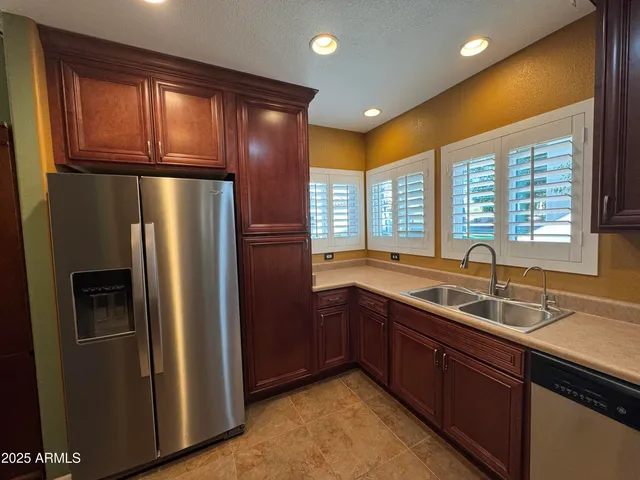 a kitchen with stainless steel appliances granite countertop a refrigerator and a sink
