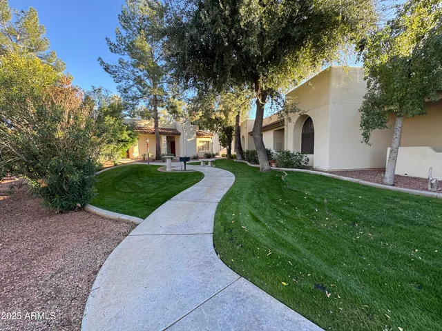 a front view of a house with a yard and trees