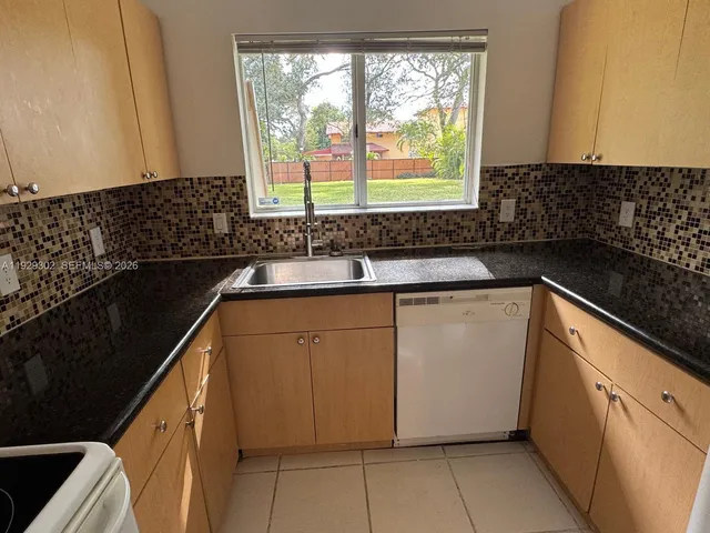 a kitchen with granite countertop a sink and a stove