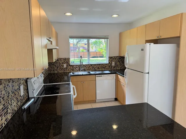 a kitchen with a refrigerator and a sink