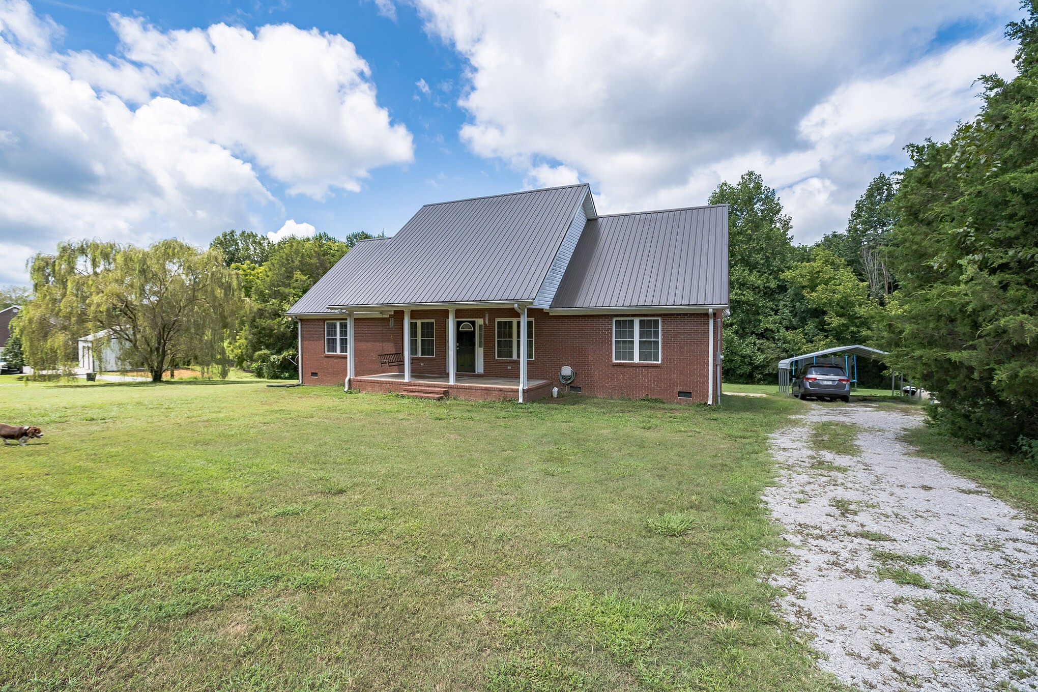 420 Sands Road Pulaski, TN 38478 - Photo 3 of 36 a front view of a house with a garden and trees