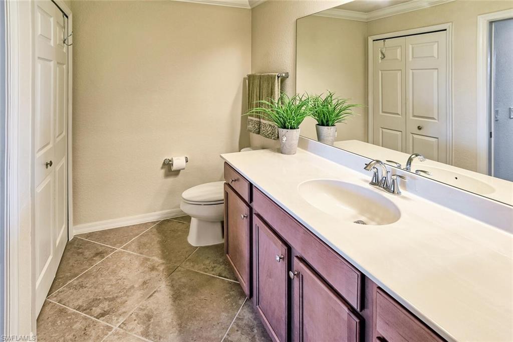 9719 Acqua Court, Unit 228 Naples, FL 34113 - Photo 13 of 35 a bathroom with a sink and a mirror