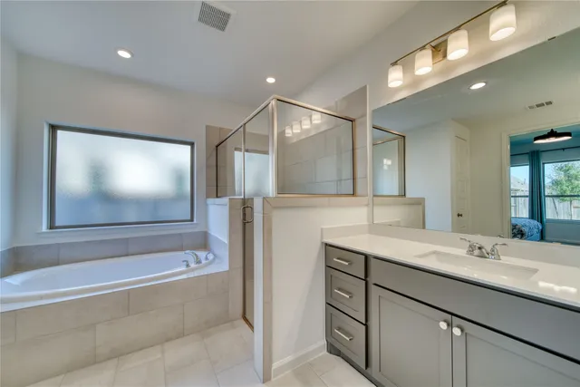 a bathroom with a sink a large mirror and a bathtub