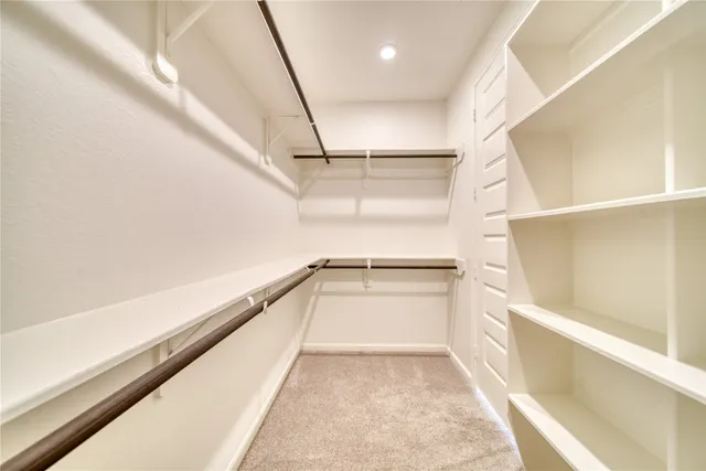 a view of walk in closet with empty racks