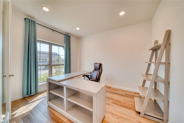 a view of a workspace with furniture and a window