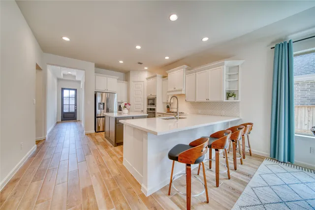 a large kitchen with stainless steel appliances kitchen island granite countertop a large island in the center