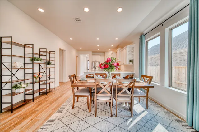 a dining room with furniture and a floor to ceiling window