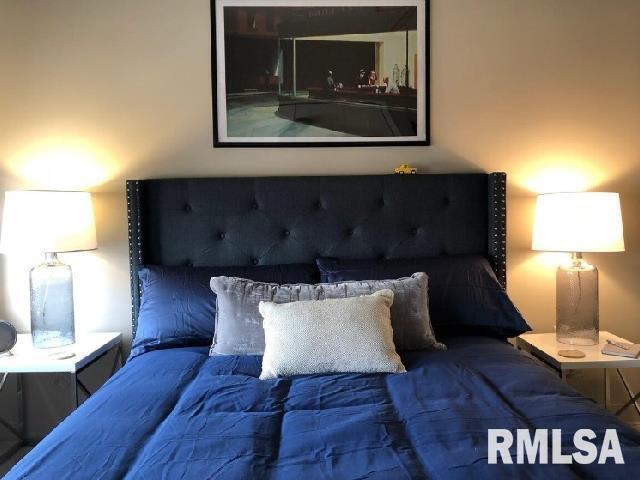 501 15th Street, Unit 802 Moline, IL 61265 - Photo 4 of 6 a living room with a couch and a lamp on dresser