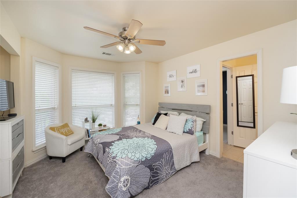 135 Kirkpatrick Road Ennis, TX 75119 - Photo 34 of 40 a bedroom with a bed and a chandelier