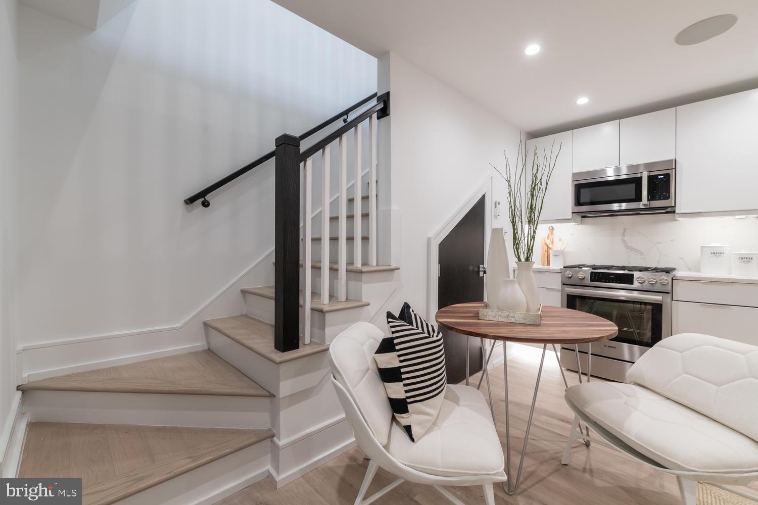 1524 18th Street Northwest, Unit 1 Washington, DC 20036 - Photo 11 of 20 a kitchen with stainless steel appliances kitchen island granite countertop a stove a microwave a dining table and chairs