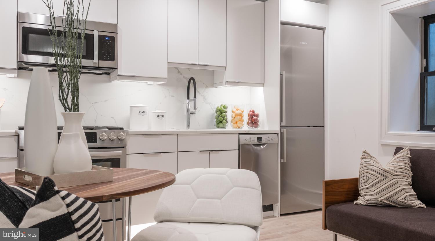 1524 18th Street Northwest, Unit 1 Washington, DC 20036 - Photo 13 of 20 a kitchen with stainless steel appliances kitchen island granite countertop a refrigerator stove top oven and sink
