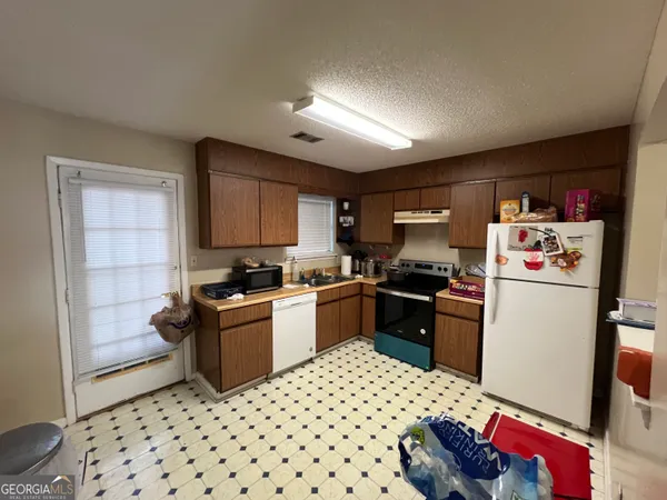 a kitchen with a refrigerator and a stove top oven