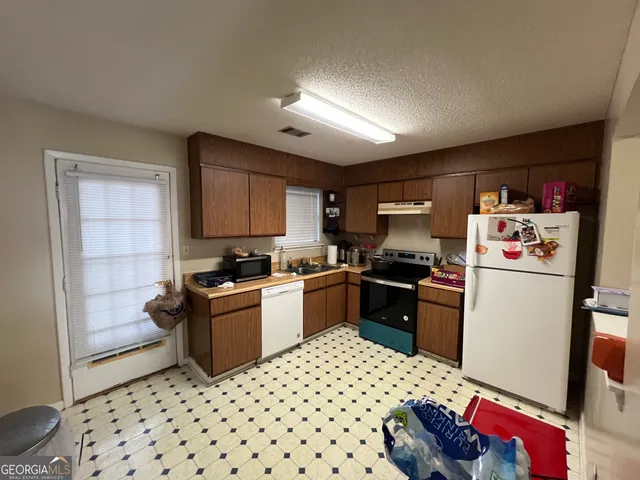 a kitchen with a refrigerator and a stove top oven