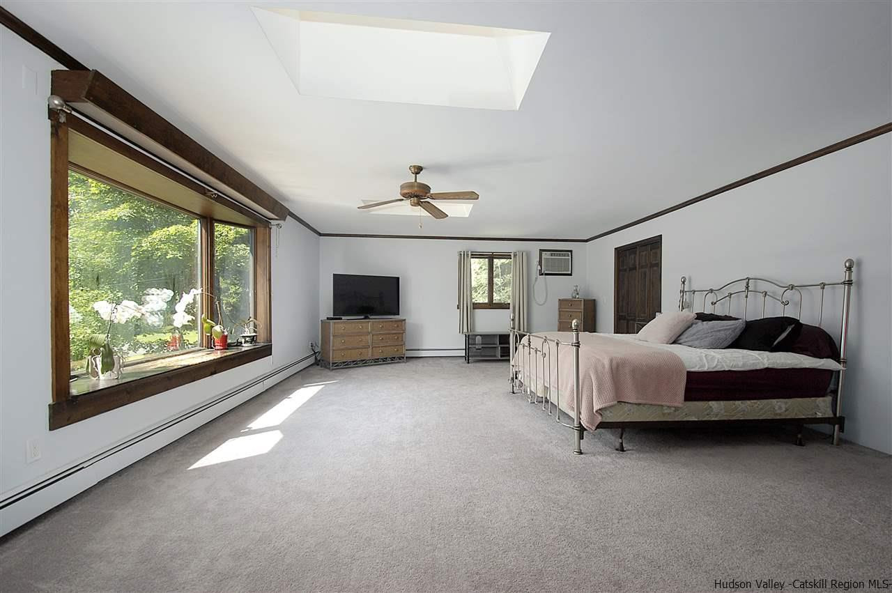 8 Jansen Road Stone Ridge, NY 12484 - Photo 17 of 28 a spacious bedroom with a large bed and a large window