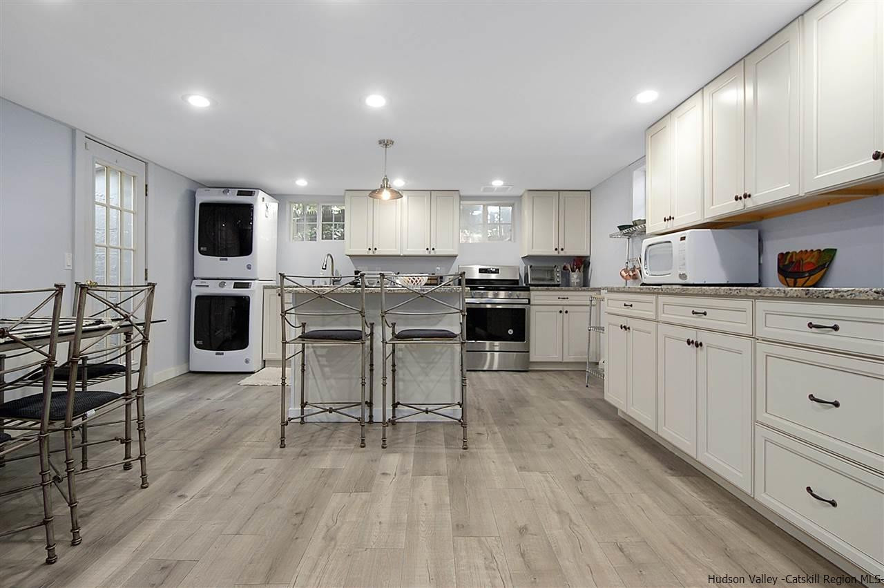 8 Jansen Road Stone Ridge, NY 12484 - Photo 8 of 28 a kitchen with stainless steel appliances kitchen island granite countertop a table chairs microwave and sink