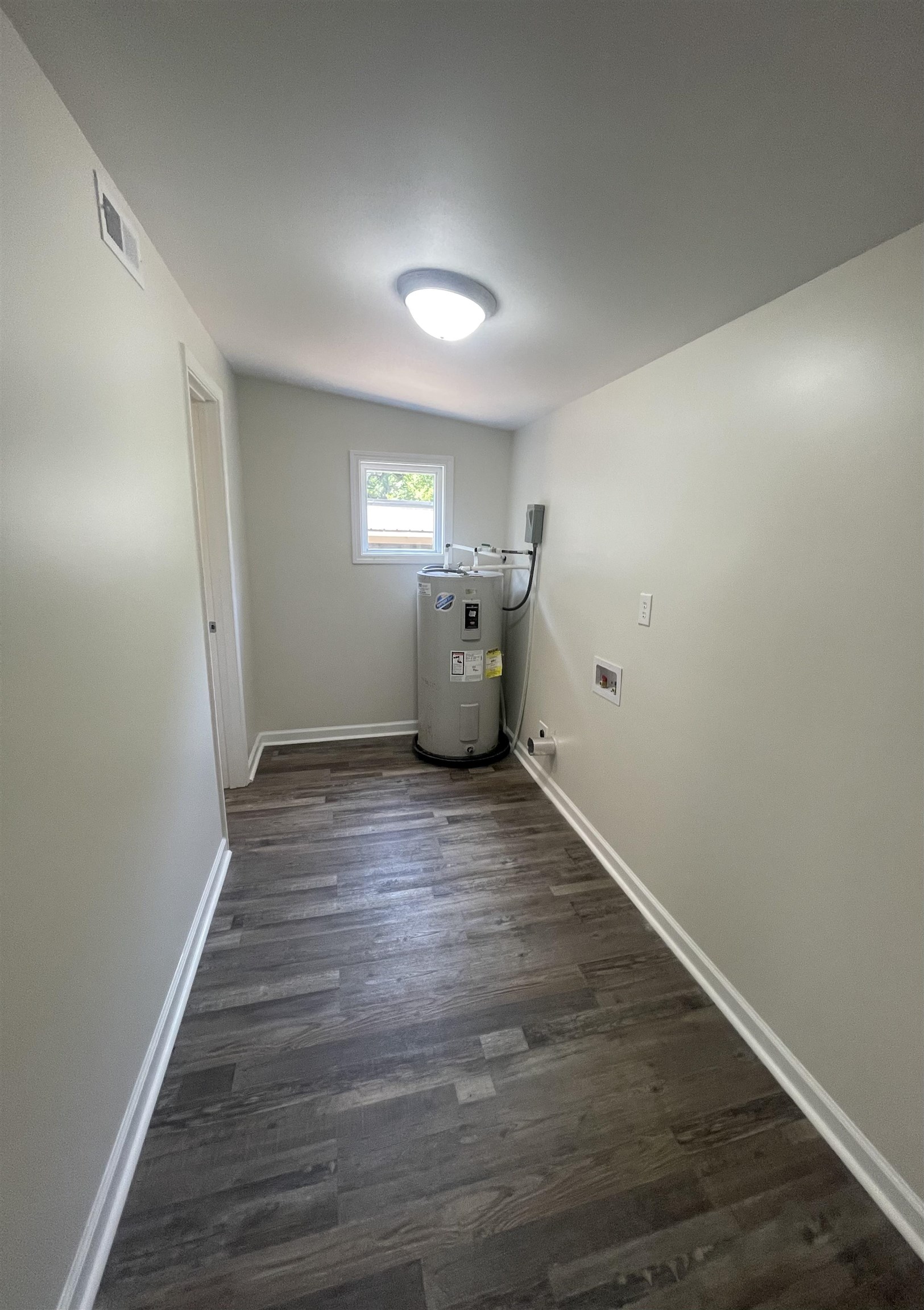 815 Fawn Road Oakland, TN 38060 - Photo 27 of 29 Laundry room featuring water heater, dark wood-style flooring, baseboards, and hookup for a washing machine