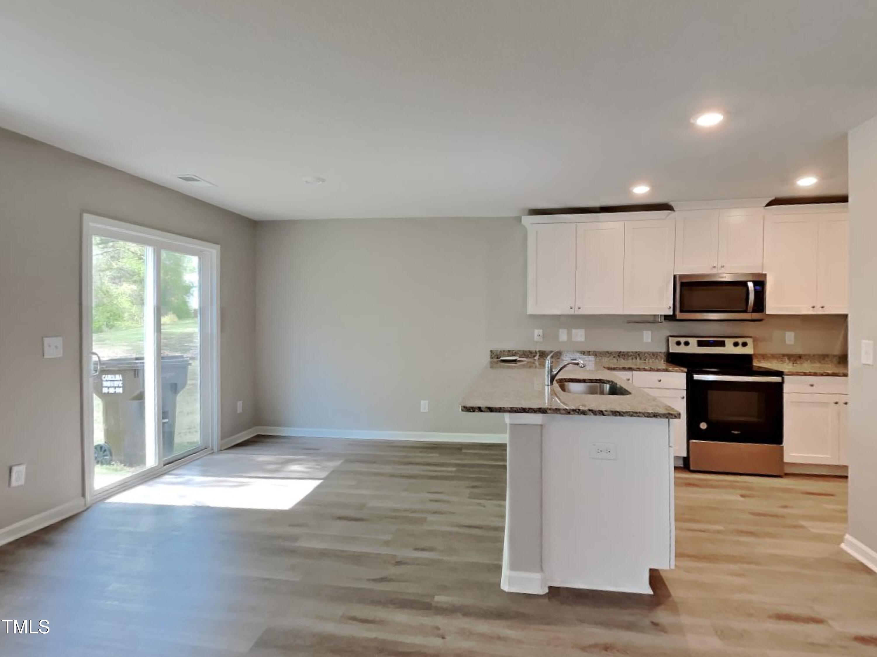 342 Coleshill Road Angier, NC 27501 - Photo 3 of 15 a kitchen with granite countertop a stove top oven and cabinets