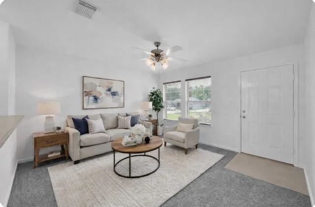 an empty room with windows and fan