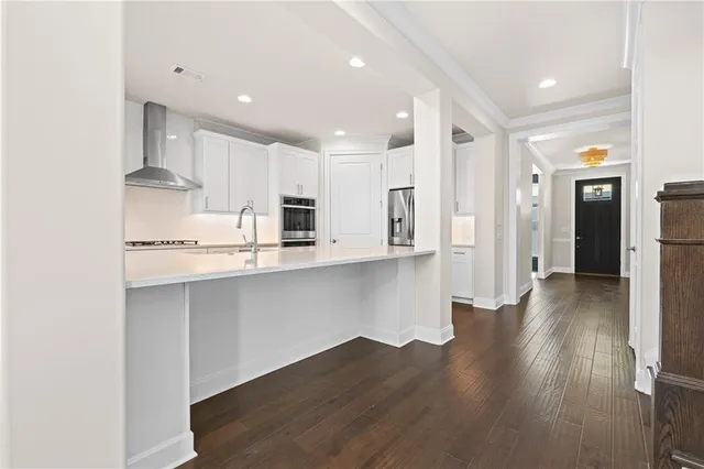 an empty room with wooden floor fireplace and windows