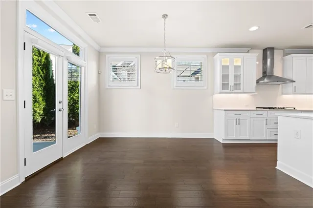 an empty room with wooden floor fireplace and windows