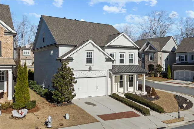 a view of a white house with large windows next to a road
