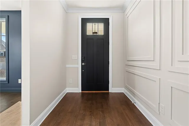 a view of a hallway with wooden floor and entryway