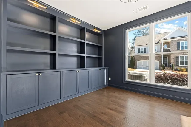 a view of an empty room with cabinet and a window
