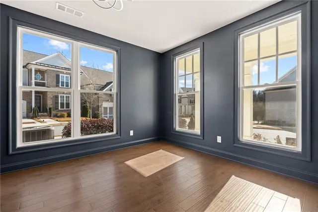 a kitchen with stainless steel appliances granite countertop a refrigerator a stove oven a sink dishwasher and white cabinets with wooden floor