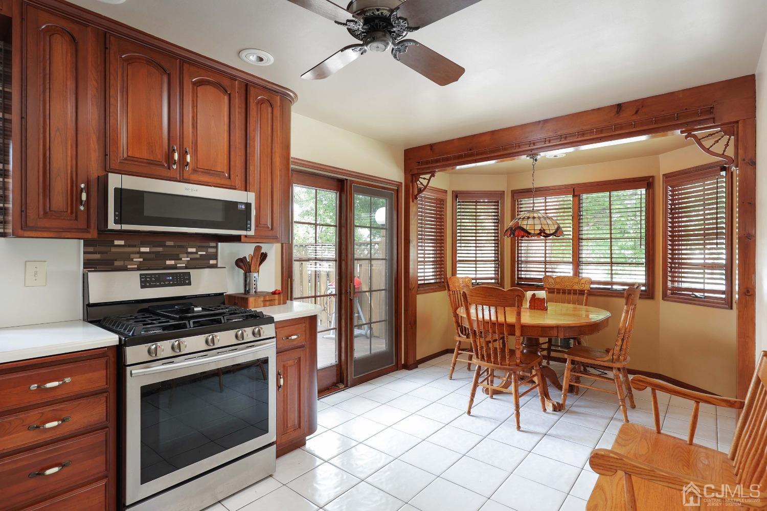 10 Gramercy Road Old Bridge, NJ 08857 - Photo 20 of 31 a kitchen with stainless steel appliances granite countertop a stove a sink dishwasher a dining table and chairs with wooden floor