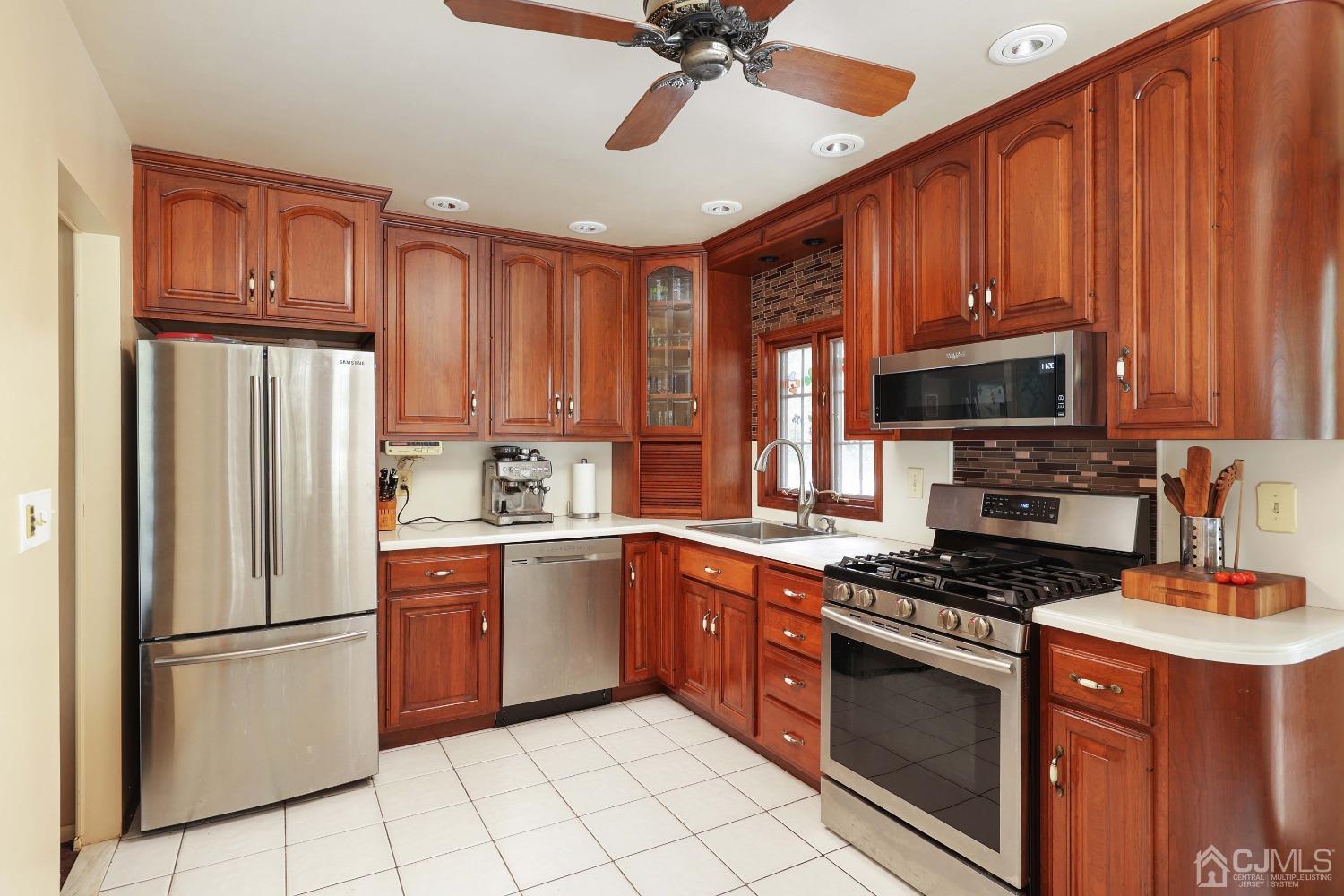 10 Gramercy Road Old Bridge, NJ 08857 - Photo 21 of 31 a kitchen with stainless steel appliances granite countertop a stove top oven a refrigerator a sink and dishwasher with wooden floor