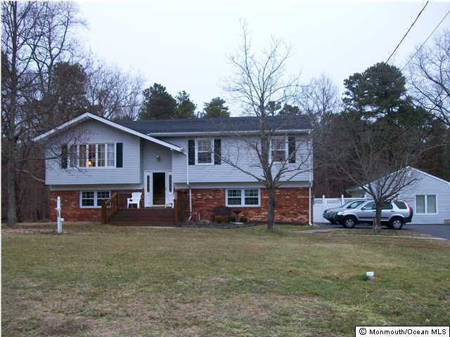 a front view of a house with a garden and trees