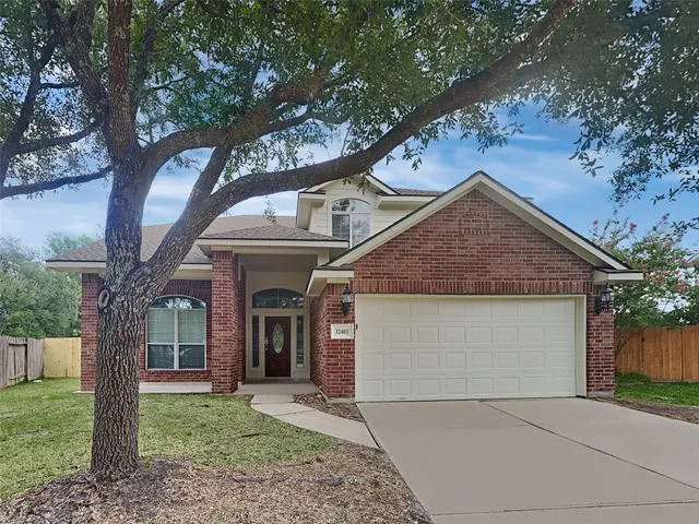 a front view of a house with a garden and trees